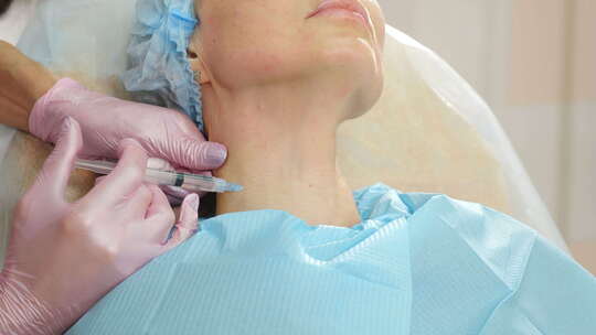 美容院美容诊所女病人颈部注射肉毒杆菌毒素