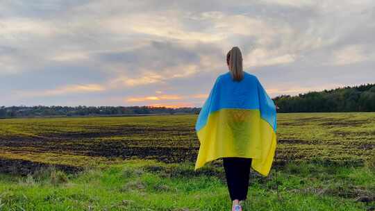 日落时拿着乌克兰国旗的女孩4K视频素材模板下载