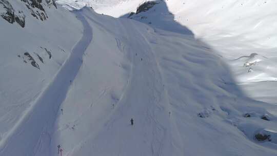 在阳光明媚的阿尔卑斯山斜坡上滑雪后的无人驾驶飞机视图