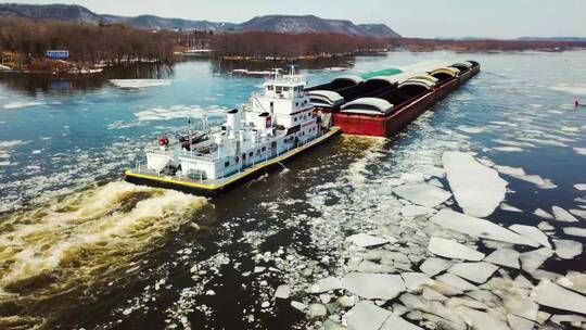 航拍在有冰的河上航行的驳船