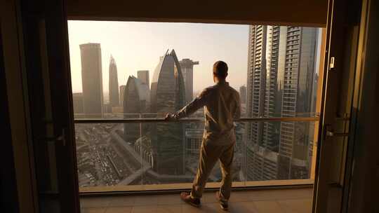 男人站在阳台上观看城市风景