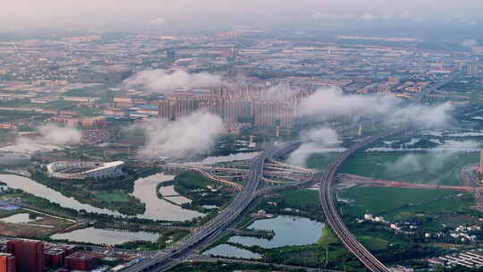 航拍清晨城市云海下的交通枢纽