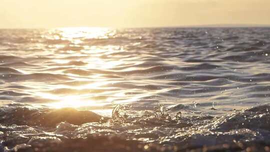 夕阳下海边海浪拍打礁石