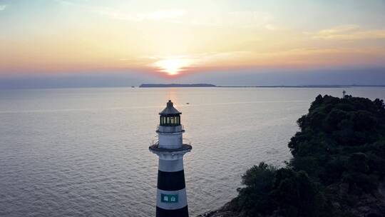 夕阳下航拍海边的灯塔