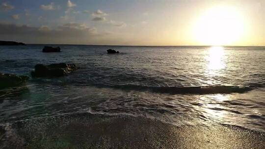 日出下击打沙滩的海浪