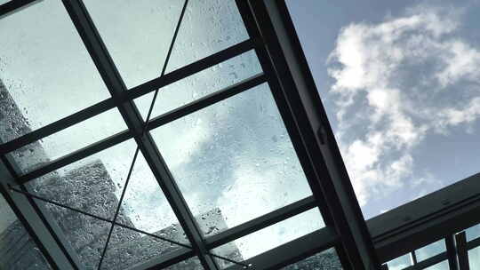 透过建筑物上的玻璃屋顶拍摄天空。