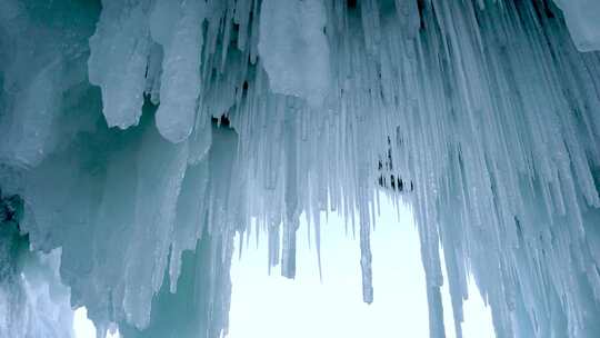 冰洞内，白色半透明的冰柱，粗细不一。