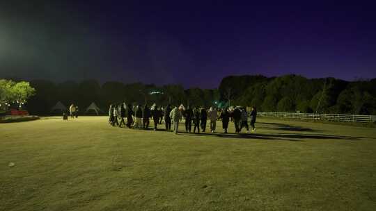 夜晚户外一群人在空旷场地聚集活动