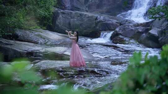 实拍山间小溪高山瀑布跳舞的女孩