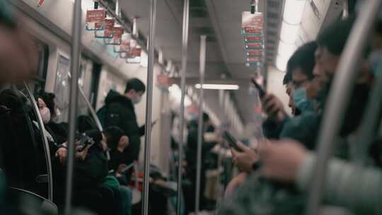地铁上看手机的人们