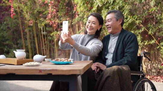 老年夫妇在庭院使用手机视频素材模板下载