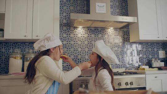 姐妹在厨房互相喂食视频素材模板下载