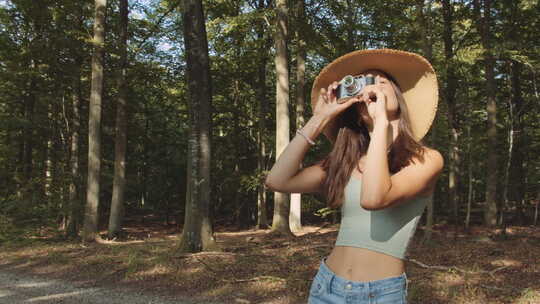 森林中的少女使用旧相机