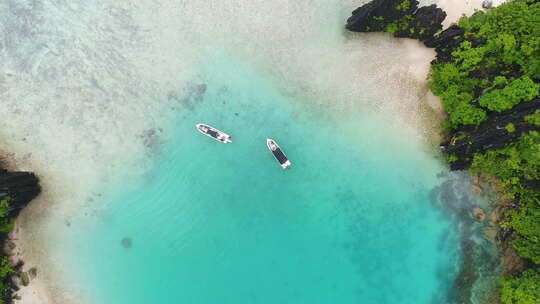 在菲律宾巴拉望清澈的海水上拉出快艇的空中俯视图