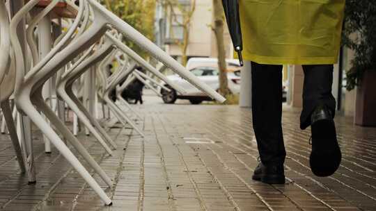 雨中欧洲城市路灯上带伞和雨衣的商人游客