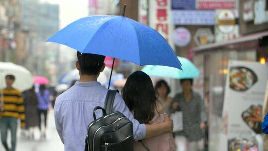 夫妇共享一把雨伞