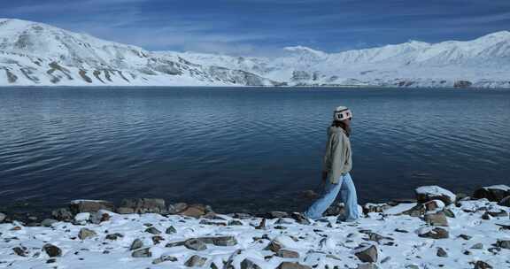 年轻女子从湖边走过徒步旅行雪山湖泊