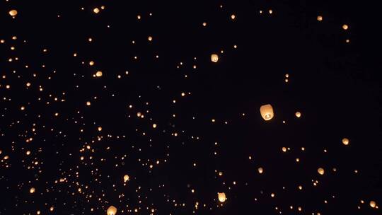 发光的纸天灯在晚上漂浮在天空中