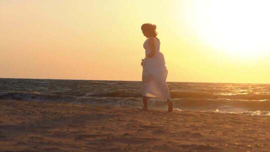 夕阳下，在沙滩上奔跑的连衣裙女孩
