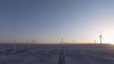 航拍新疆阿勒泰冬季雪原夕阳晚霞戈壁风电场高清在线视频素材下载