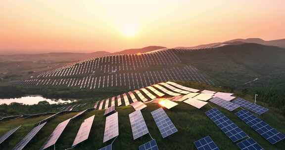 夕阳下山坡上的太阳能光伏发电站航拍