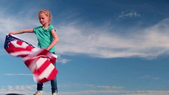 夏季美国国旗之国，金发女孩在蓝天上挥舞美国国旗
