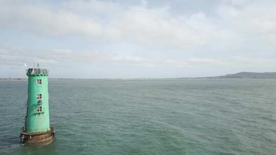 爱尔兰都柏林湾白天平静的水中的北牛灯塔。-普尔巴克