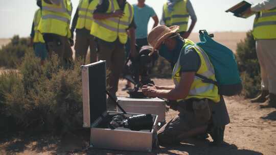 沙漠中电影片场的一个男人擦去沙子上的镜头。