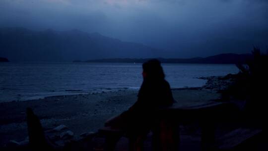 夜晚女子坐在沙滩看风景视频素材模板下载