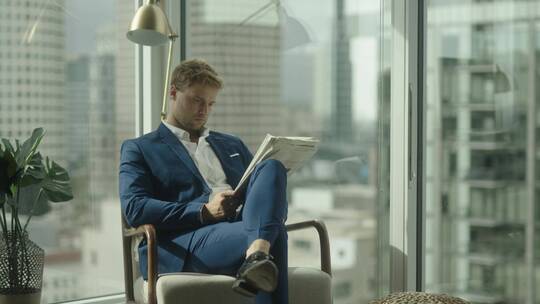 男人坐在办公室里读报纸视频素材模板下载