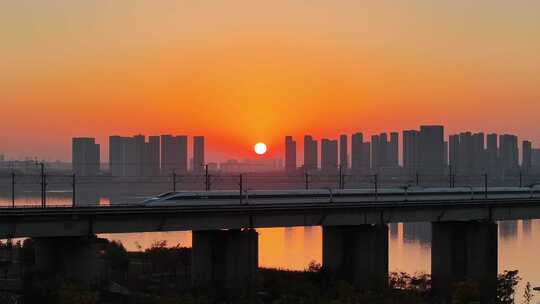 唯美黄昏日落下的高铁驶过桥梁