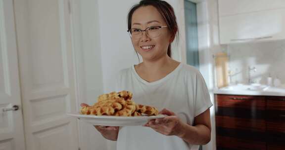 妈妈给她的孩子们提供新鲜烹饪的华夫饼