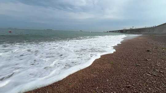 海边4k拍摄沙滩海浪延时阴天堤坝