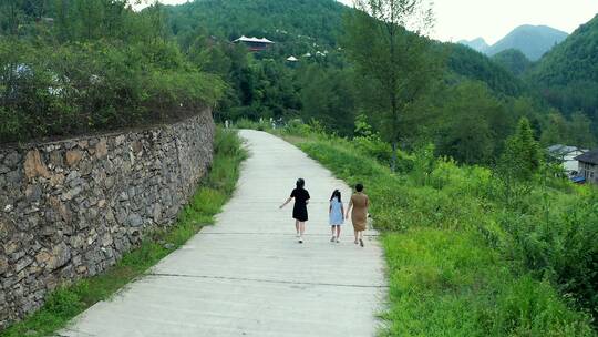 4K航拍旅游走在乡间小路上母亲和两个女儿