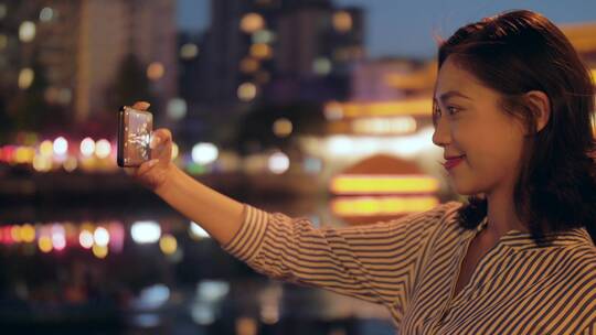 快乐中国女青年夜游成都府河用手机拍照