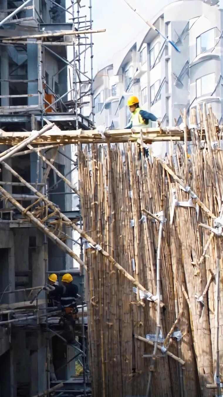 工人在建筑工地搭建竹脚手架