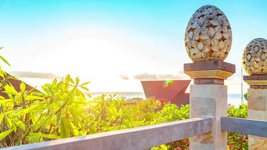 巴厘岛阿梅德海滩日出与海面背景下的灯笼花卉图案雕塑沙石