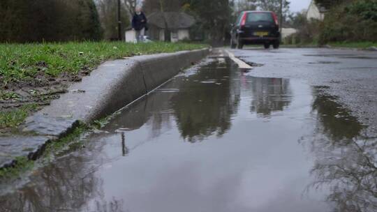 雨滴降落在地面水坑中的特写镜头