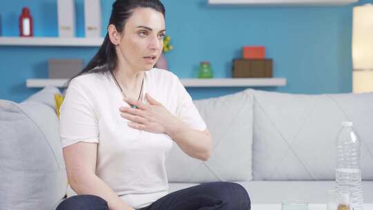 沙发上抚胸面露不适