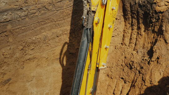 挖掘机铲斗在深坑中挖土