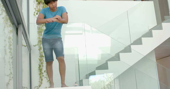 十几岁的亚洲男孩站在现代楼梯上，有复印空