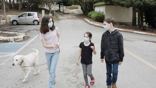 三个儿童一只狗狗带口罩在街上散步