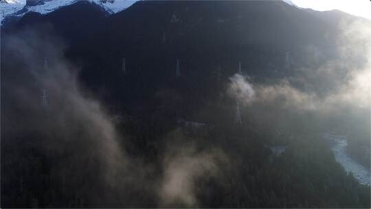 云雾缭绕的高原杉林电网电塔