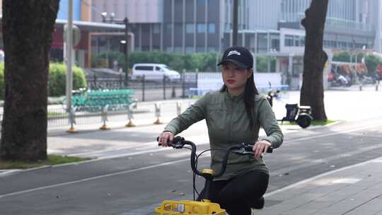 女子城市街道骑行共享单车