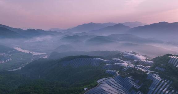 新能源太阳能光伏发电站夕阳下山坡航拍