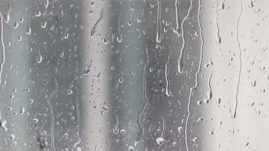 雨水倾泄到玻璃上水珠滚落！