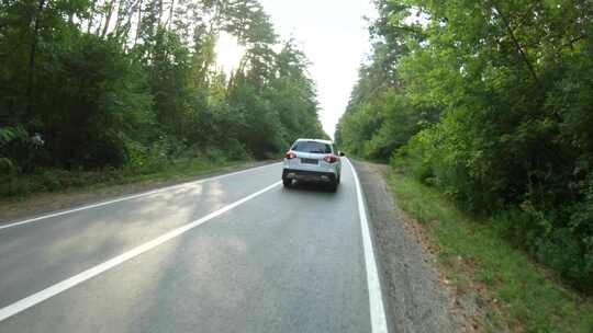 航拍汽车穿过森林乡村公路白色越野车在附近