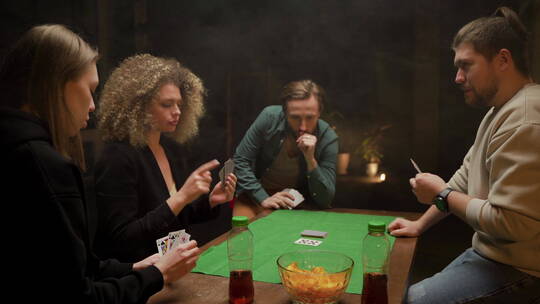 朋友围着桌子玩扑克 