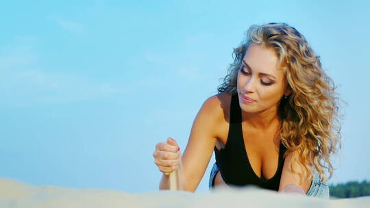 女人在沙滩上玩沙子