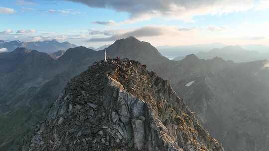 两个人站在奥地利不锈钢山十字架的顶峰上。Hohe Tauern-Gl？ dis